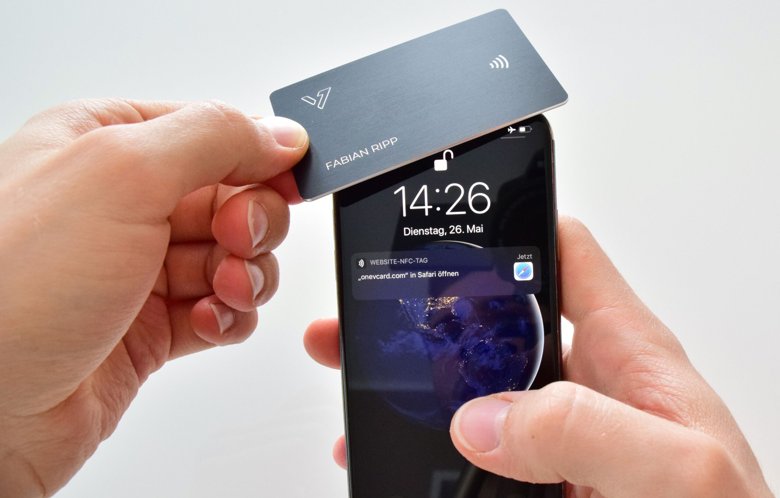 Metall Visitenkarte wird an das Handy gehalten um den QR-Code über NFC zu scannen